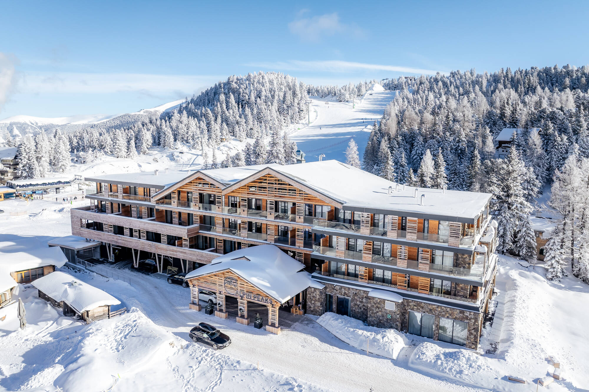 Hotel im verschneiten Bergwald, Drohnenaufnahme im Winter