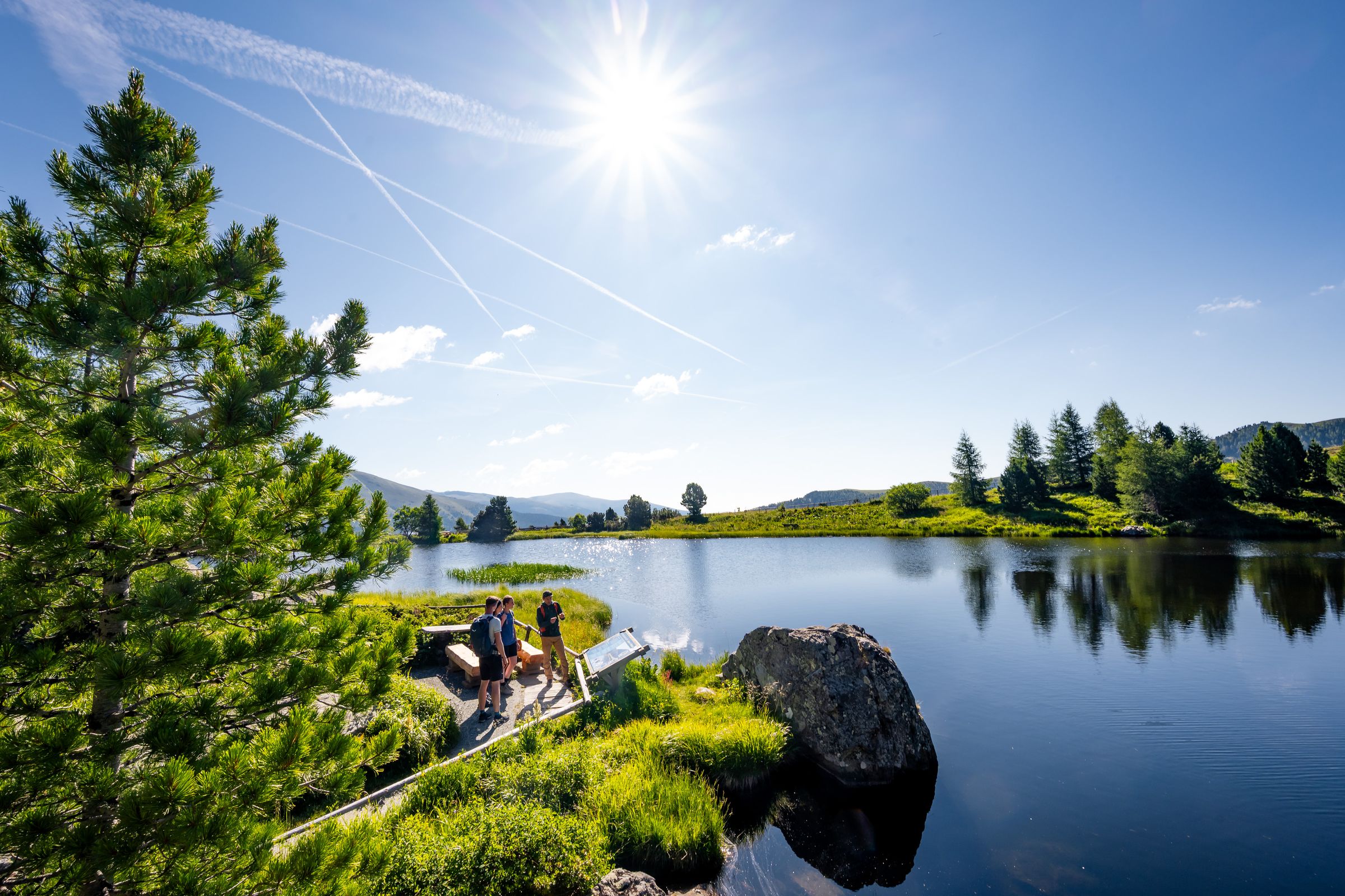 Wanderer an einem Bergsee in den Nockbergen an der Nockalmstraße in Kärnten – Tourismusfotografie
